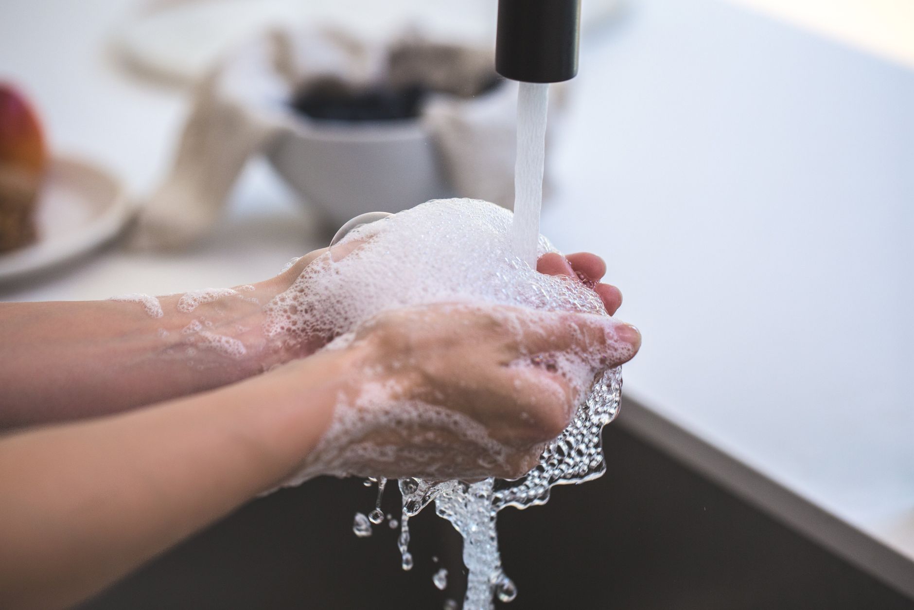 Close-up of hands being washed with foamy soap under a faucet, highlighting hygiene and cleanliness. (Photo by Burst on Pexels)